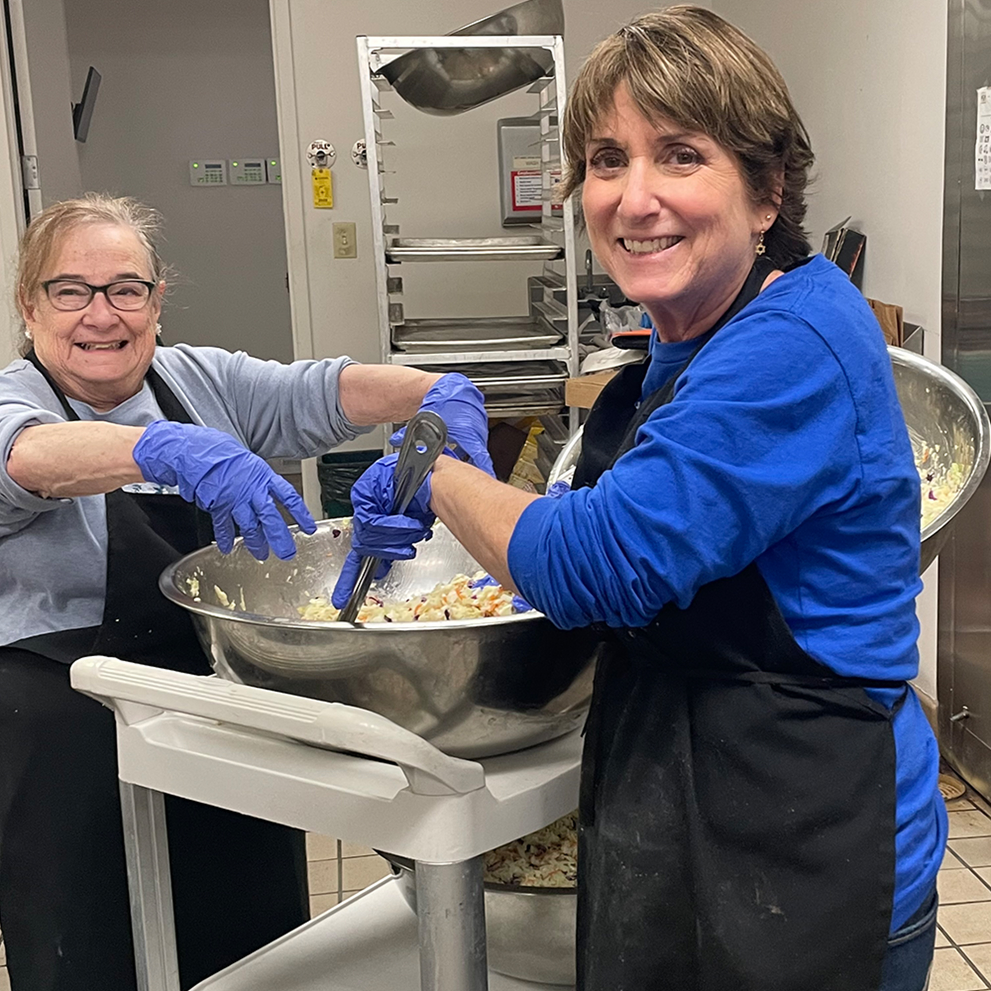 alt_two_women_smiling_baking_in_community_kitchen